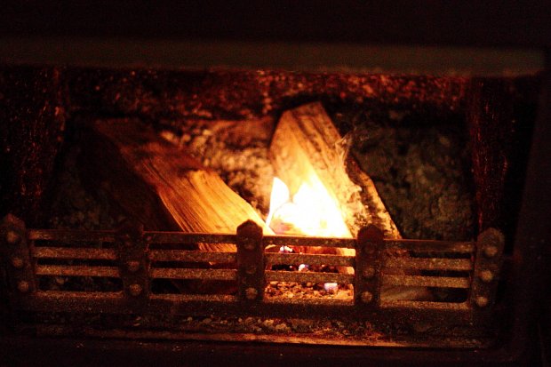 I rake the ash so as to provide a firm base which the firelighter won't sink into and get smothered. Place 2 logs in parallel with a small gap between them where you place your lit firelighter